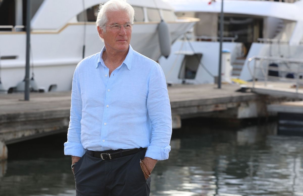 Richard Gere wearing a light blue shirt and gray pants at a photocall in France