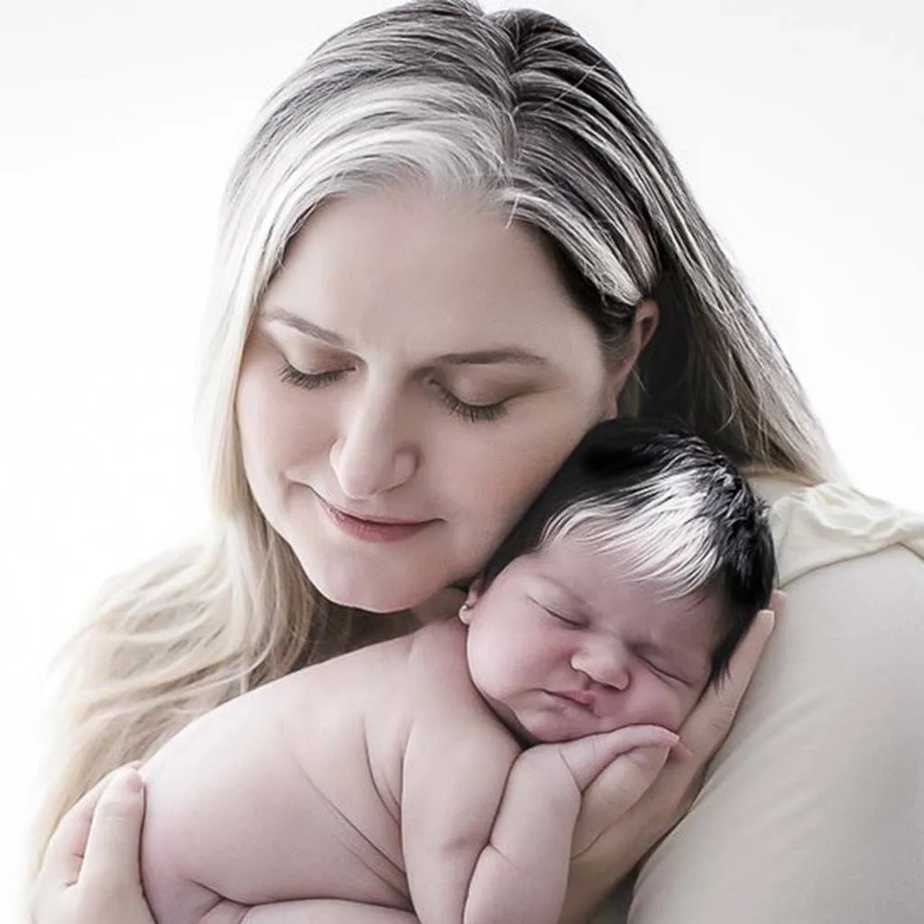 The newborn with white hair exudes a unique and captivating charm that captures everyone’s attention.